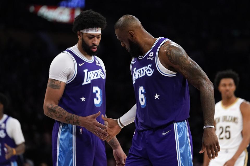 All-Star forward Anthony Davis and LeBron James slap hands during a game last season.