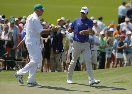 Australia's Adam Scott takes his putter from caddie Steve Williams on the second hole during the third round of the Masters golf tournament at the Augusta National Golf Club in Augusta, Georgia April 12, 2014. REUTERS/Brian Snyder/Files