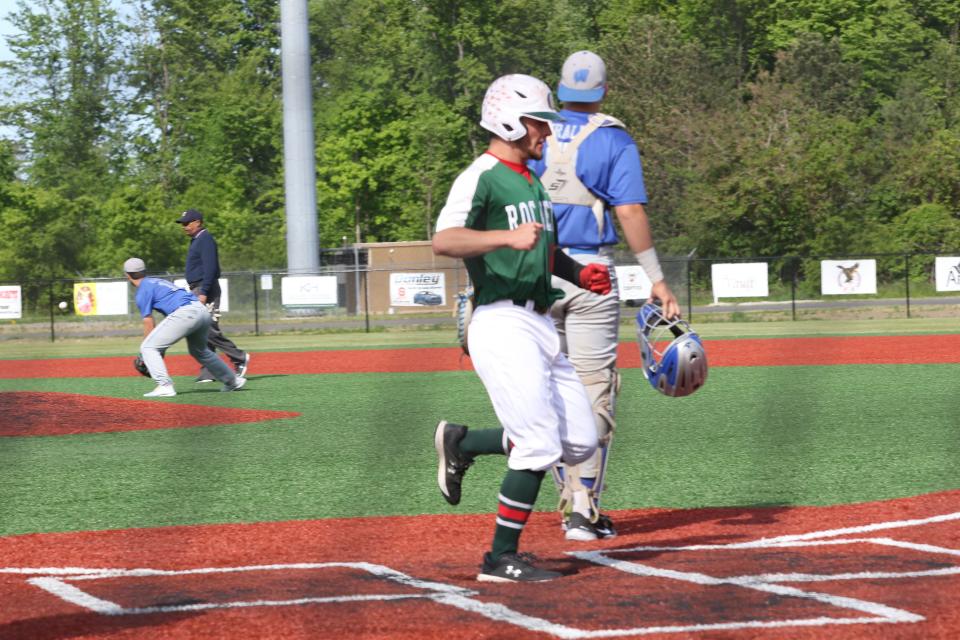 Oak Harbor's Brayden Butzin scores a run.