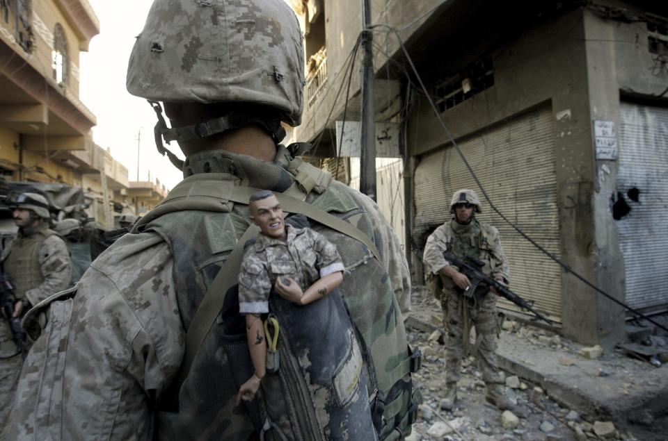 FILE - A U.S. Marine of the 1st Division carries a mascot for good luck in his backpack as his unit pushed further into the western part of Fallujah, Iraq, Nov. 14, 2004. (AP Photo/Anja Niedringhaus, File)
