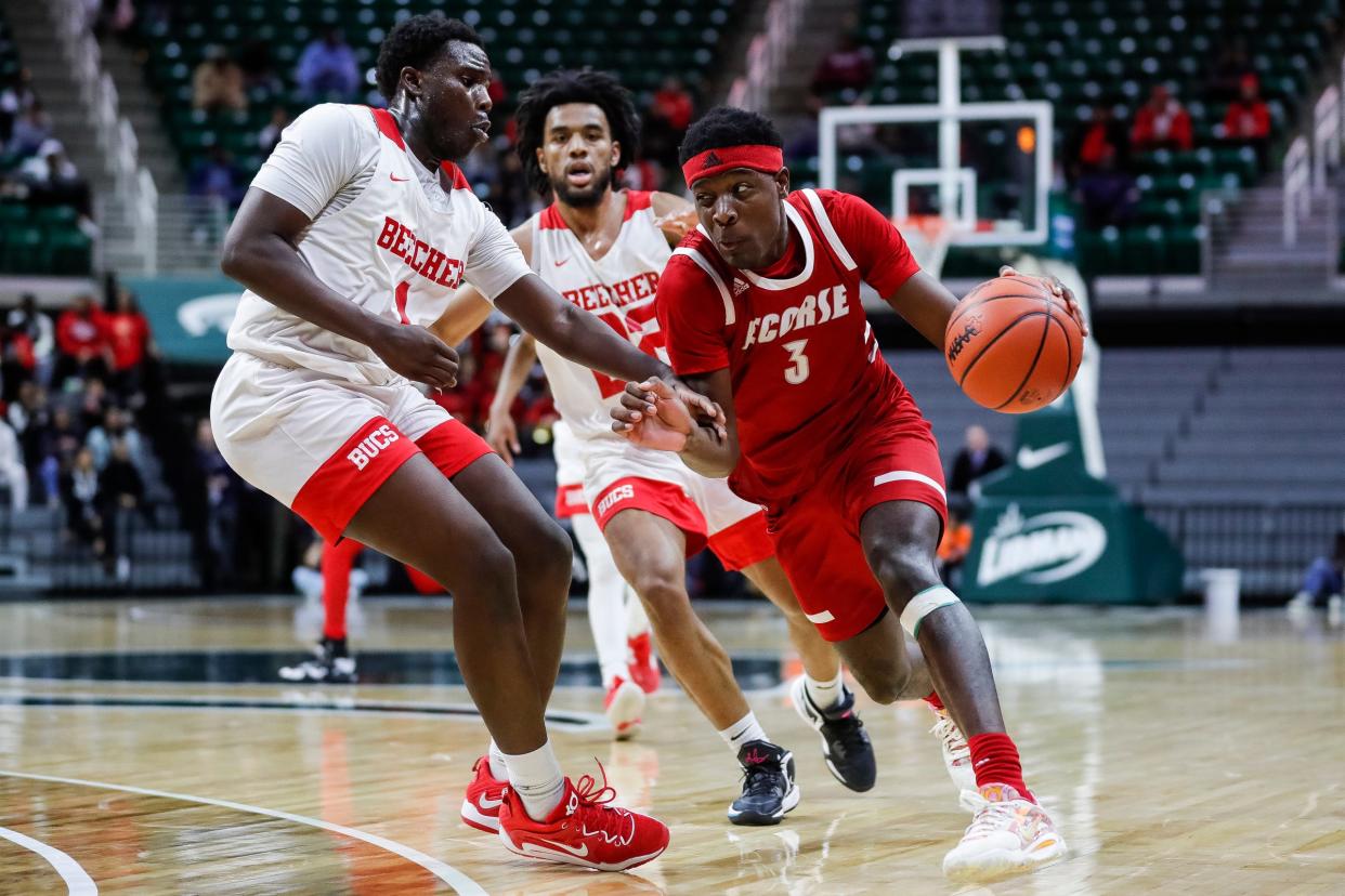 Ecorse guard Malik Olafioye (3) dribbles against Flint Beecher forward Kevin Tiggs Jr (1) during the first half of the MHSAA boys Division 3 semifinals at Breslin Center in East Lansing on Thursday, March 23, 2023.