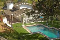 <p>The pool area is surrounded by lush green trees and perfectly manicured lawns.</p>