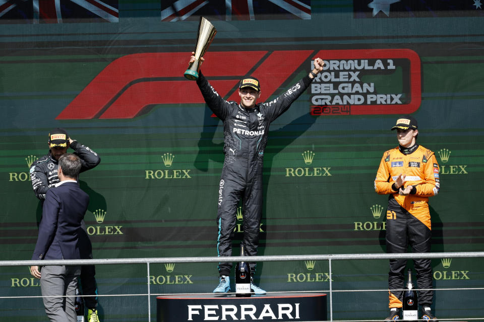 El británico George Russell de Mercedes en el primer lugar, celebra con su compañero Lewis Hamilton, segundo, y Oscar Piastri de McLaren, tercero, en el podio tras el Gran Premio de Bélgica en Spa-Francorchamps el domingo 28 de julio del 2024. (AP Foto/Geert Vanden Wijngaert)