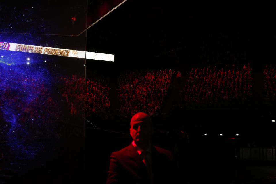 A security guard stands during the final of League of Legends tournament between Team G2 Esports and Team FunPlus Phoenix, in Paris, Sunday, Nov. 10, 2019. The biggest e-sports event of the year saw a Chinese team, FunPlus Phoenix, crowned as world champions of the video game League of Legends. Thousands of fans packed a Paris arena for the event, which marked another step forward for the growing esports business. (AP Photo/Thibault Camus)