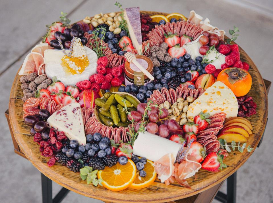 Salami, cheeses, pickles, fruit, honey and nuts cover a grazing board by Board & You, which is coming to Indianapolis' north side.