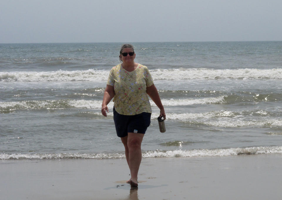Suzanne Hornick walks from the surf in Ocean City N.J. on July 8, 2021. She is a leader of a residents group that opposes three offshore wind energy projects approved for the ocean off Ocean City. (AP Photo/Wayne Parry)