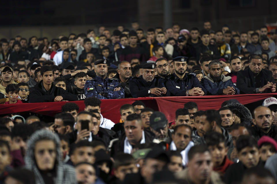Hamas police officers and residents watch a live broadcast of the World Cup semifinal soccer match between Morocco and France played in Qatar, at the municipality stadium in Rafah refugee camp, Southern Gaza Strip, Wednesday, Dec. 14, 2022. (AP Photo/Adel Hana)