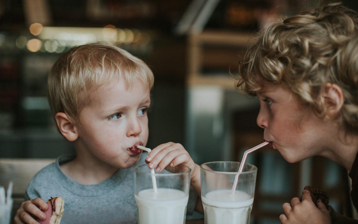 Two children drinking glasses of milk with straws - Catherine Falls Commercial