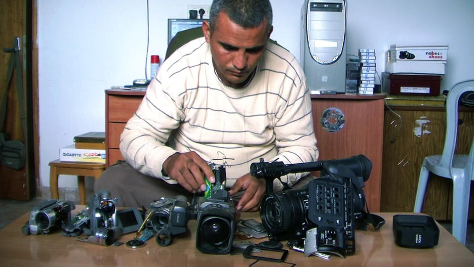 This undated publicity photo released by Kino Lorber, Inc. shows Co-director Emad Burnat with his five broken cameras. Burnat and Guy Davidi co-directed the documentary film, "5 Broken Cameras." (AP Photo/Kino Lorber, Inc.)