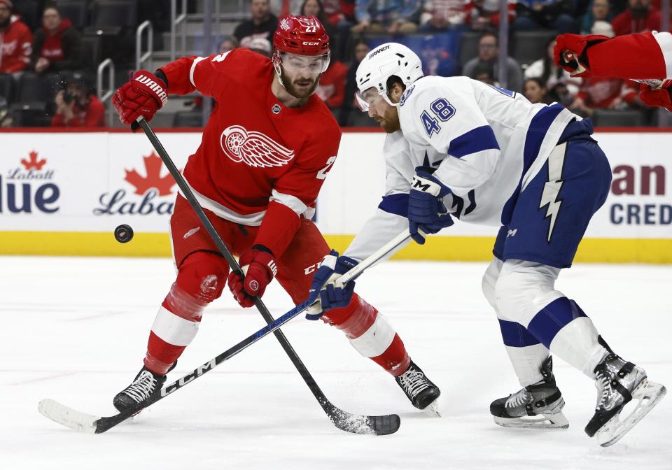 Tampa Bay Lightning defenseman Nick Perbix (48) knocks the puck away from Detroit Red Wings center Michael Rasmussen (27) in front of the goal during the first period of an NHL hockey game Sunday, Jan. 21, 2024, in Detroit. (AP Photo/Duane Burleson)