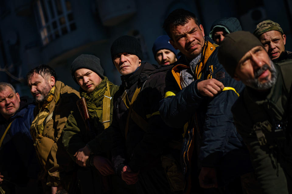 Volunteers for the Territorial Defense Forces stand in formation, check their weapons, put on yellow armbands, get marching orders, and ship out to their posts to defend Kyiv on Feb. 28.<span class="copyright">Marcus Yam—Los Angeles Times/Getty Images</span>