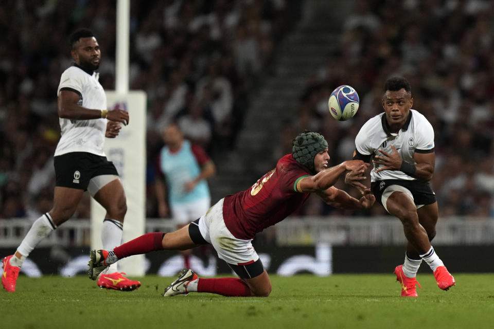 Fiji's Sireli Maqala, right, is challenged by Portugal's Pedro Bettencourt watches on during the Rugby World Cup Pool C match between Fiji and Portugal, at the Stadium de Toulouse in Toulouse, France, Sunday, Oct. 8, 2023. (AP Photo/Pavel Golovkin)