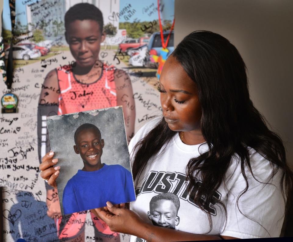 Chrisel Brown talks about her son Jeremiah Khyree Brown, 14, who was shot and killed in The Compound on Christmas 2022. She is holding one of her favorite photos of her son; behind her is a giant poster of Jeremiah that all his friends and family signed on what would have been his 15th birthday.