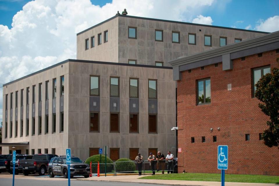 Members of law enforcement watch protestors from the Jackson County Courthouse building as a hearing in a chancery court case involving Heather Wyatt takes place on Thursday, July 18, 2024.