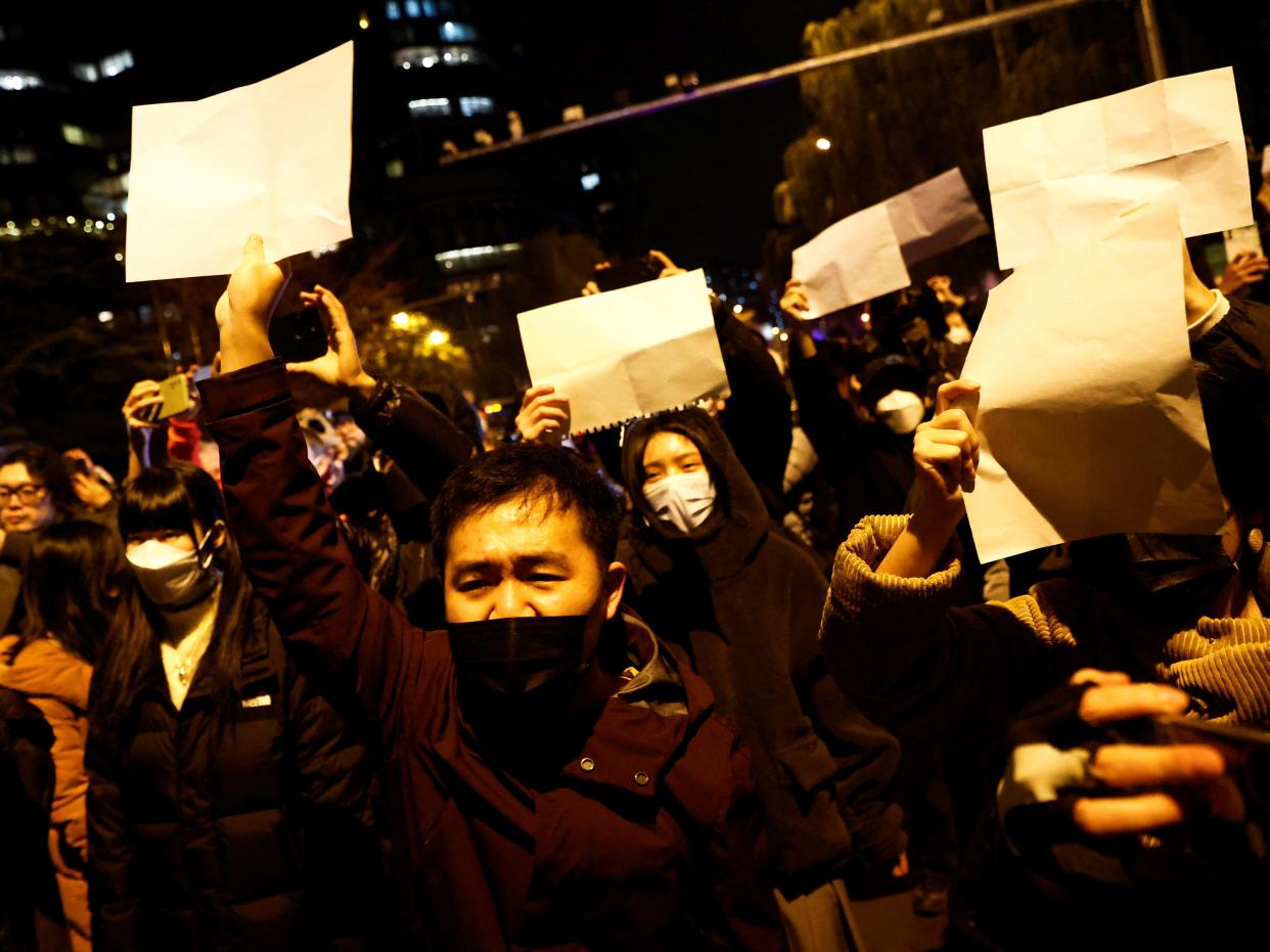 Protesters in China hold up pieces of white paper in defiance of China's COVID-zero measures