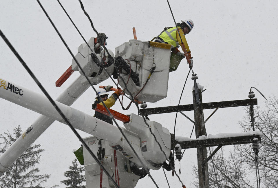 National Grid lineman Jim Sheeran, top, and Matthew Jukes fix a primary power line during a winter snow storm in Ballston Lake, N.Y. (Hans Pennink / AP)
