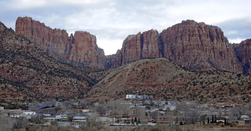 FILE - This Dec. 16, 2014, file photo, shows Hildale, Utah, sitting at the base of Red Rock Cliff mountains, with its sister city, Colorado City, Ariz., in the foreground. An appeals court has upheld a ruling that concluded two towns on the Arizona-Utah border had discriminated against people who weren't members of a polygamous sect, rejecting an argument that a judge made an error in finding there was a conspiracy between the church and towns. (AP Photo/Rick Bowmer, File)
