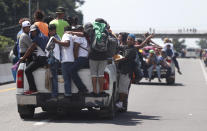 Central American migrants making their way to the U.S. in a large caravan cling to the trucks of drivers who offered them free rides, as they arrive to Tapachula, Mexico, Sunday, Oct. 21, 2018. Despite Mexican efforts to stop them at the Guatemala-Mexico border, about 5,000 Central American migrants resumed their advance toward the U.S. border Sunday in southern Mexico. (AP Photo/Moises Castillo)