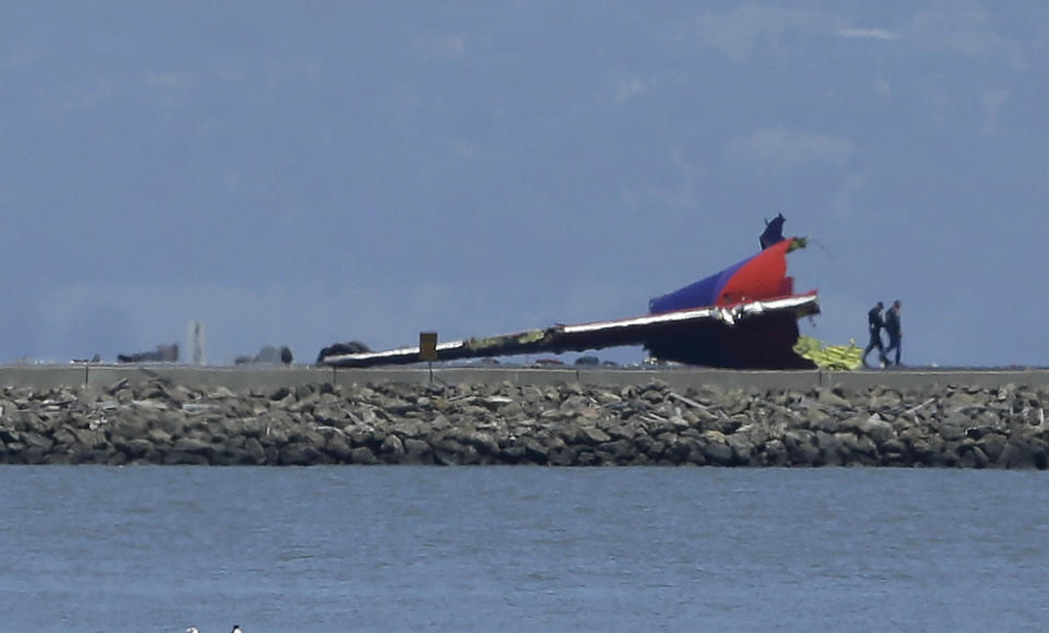 The tail of Asiana Flight 214 is seen after it crashed at San Francisco International Airport in San Francisco, Saturday, July 6, 2013. (AP Photo/Jeff Chiu)