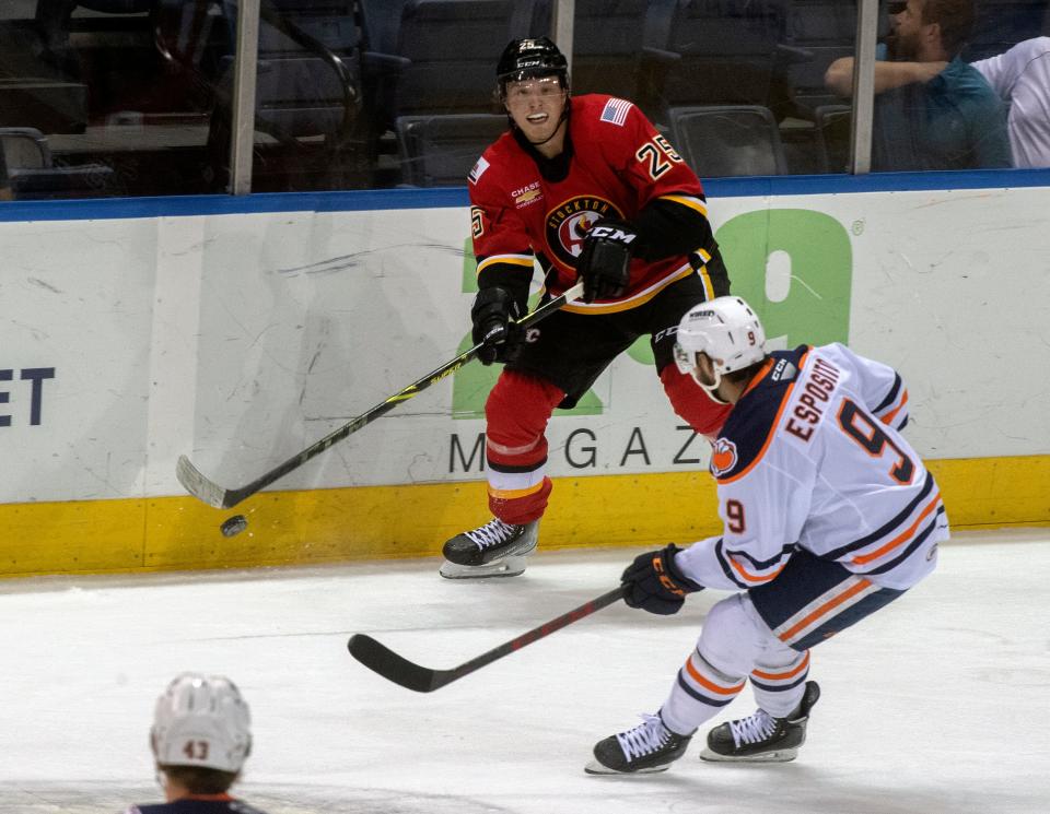 Stockton Heat's Eetu Tuulola, left, passes the puck past Bakersfield Condors' Luke Esposito during the second game of the Calder Cup playoffs.