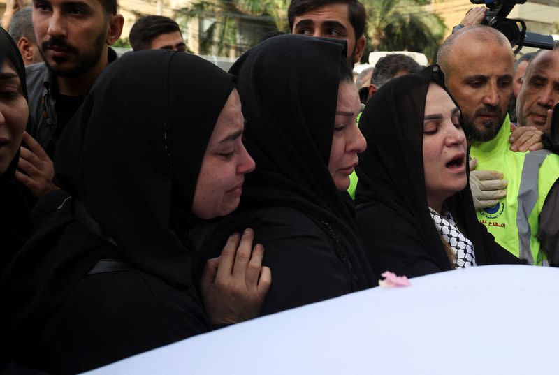Mourners stand near the coffins of the two journalists who worked with the Lebanon-based Al Mayadeen TV channel, in Beirut