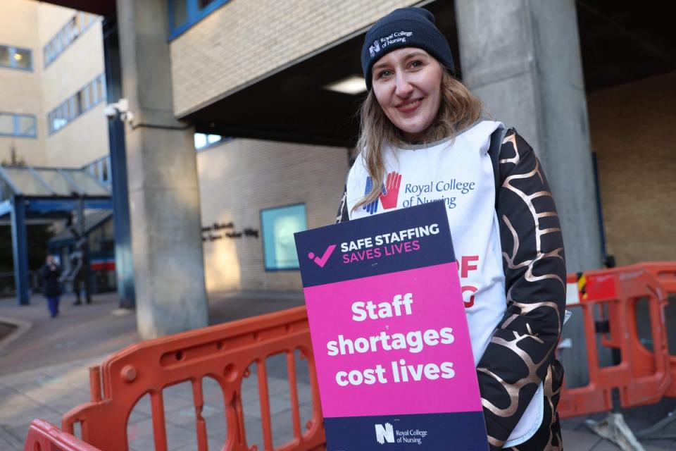 A healthcare worker holds a placard at a picket line outside St Mary’s Hospital in west London (AFP via Getty Images)