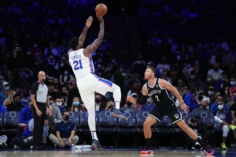 Philadelphia 76ers' Joel Embiid, left, goes up for a shot against Brooklyn Nets' Blake Griffin during the first half of a preseason NBA basketball game, Monday, Oct. 11, 2021, in Philadelphia. (AP Photo/Matt Slocum)