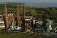 A brief patch of early morning sunlight brightens the landscape around the Greenridge Generation power plant on the banks of Seneca Lake, Friday, Oct. 15, 2021, in Dresden, N.Y. One Bitcoin mining operation in central New York came up with a novel solution in finding cheap energy to run the power-gobbling computer arrays that create and transact cryptocurrency: It took over Greenidge Generation which now produces about 44 megawatts to run 15,300 computer servers, plus additional electricity it sends into the state's power grid. (AP Photo/Julie Jacobson)