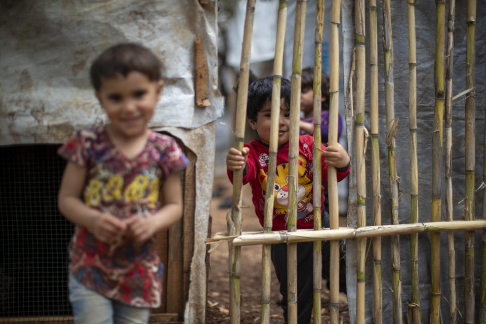 Syrian refugee children pose for a photograph at an informal refugee camp, in the town of Rihaniyye in the northern city of Tripoli, Lebanon, Thursday, April 8, 2021. For many Syrian refugee families in Lebanon, Ramadan comes as a hard life of displacement has gotten even harder after a pandemic year that deepened economic woes in their host country. (AP Photo/Hassan Ammar)