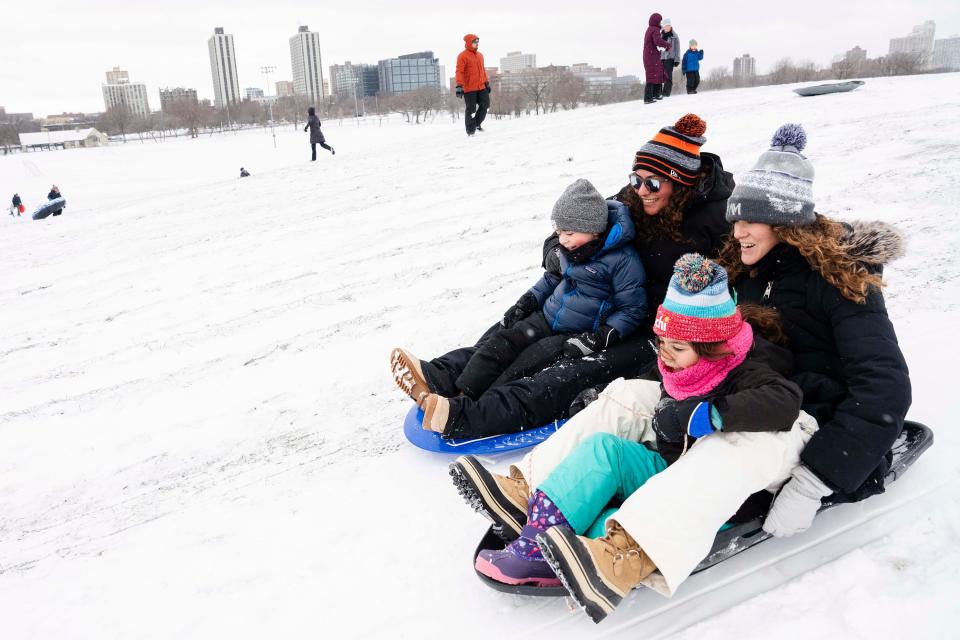 Allison Melowsky and wife Sarah Melowsky sled down Cricket Hill with their kids Parker, 7, and Zane, 4, in the Uptown neighborhood after a major snowstorm hit the Chicago area, Saturday, Jan. 13, 2024.