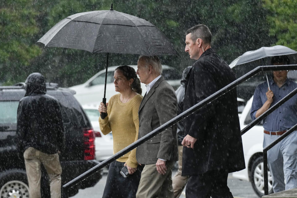 FILE - President Joe Biden walks with Annie Tomasini in the rain from St. Edmond Roman Catholic Church after attending Mass in Rehoboth Beach, Del., May 13, 2023. Biden has chosen Tomasini to be a White House deputy chief of staff. (AP Photo/Carolyn Kaster, File)