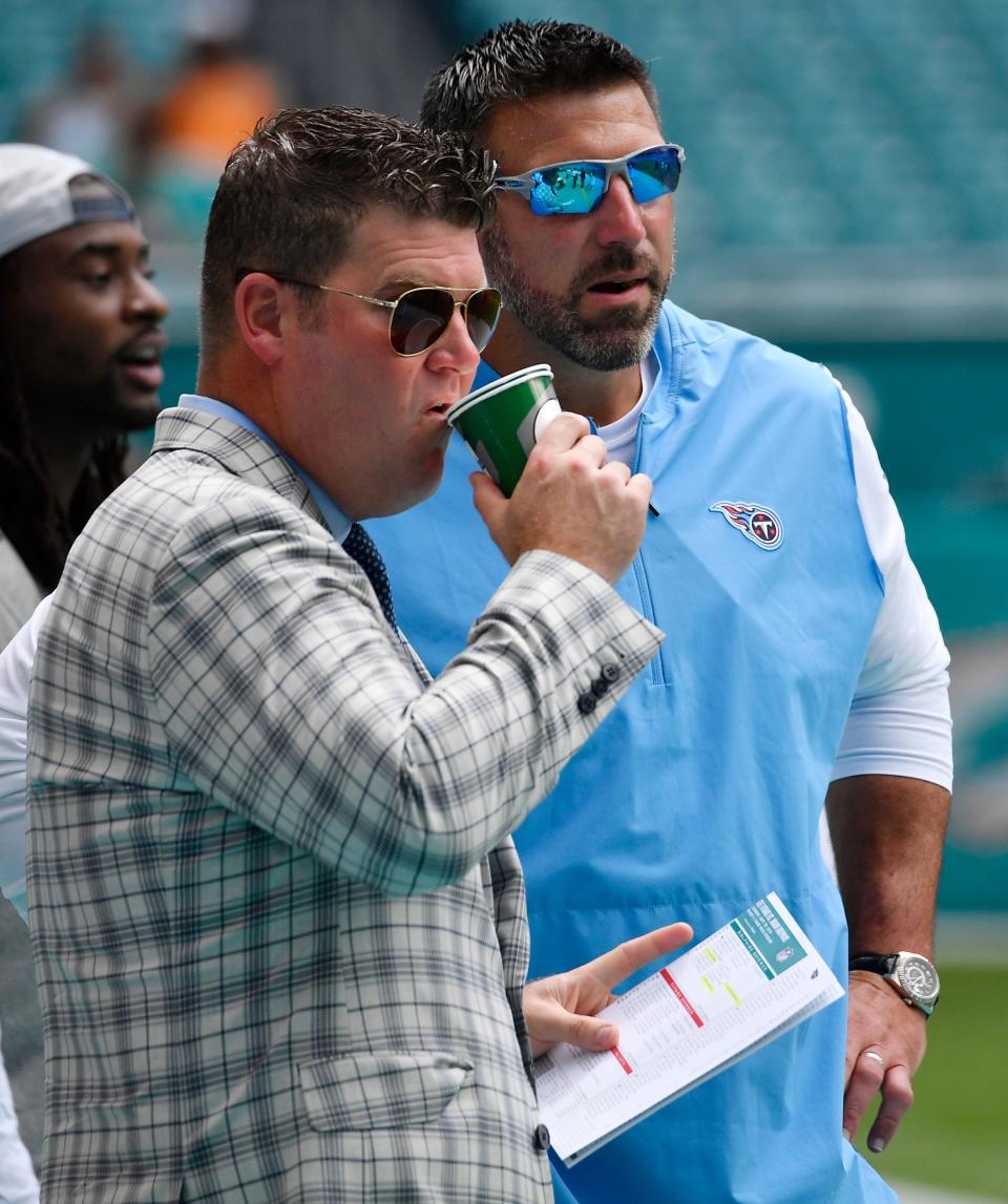 Titans general manager Jon Robinson and head coach Mike Vrabel watch warmups before the game against the Dolphins at Hard Rock Stadium Sunday, Sept. 9, 2018, in Miami Gardens, Fla.