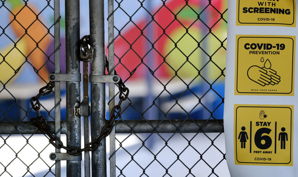 A chain-link fence lock is seen on a gate at a closed Ranchito Elementary School in the San Fernando Valley section of Los Angeles on Monday, July 13, 2020. Amid spiking coronavirus cases, Los Angeles Unified School District campuses will remain closed when classes resume in August, Superintendent Austin Beutner said Monday. (AP Photo/Richard Vogel)