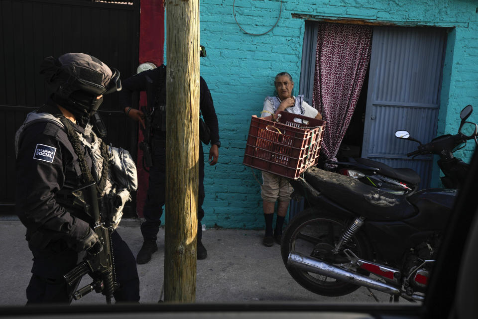 Agentes de la policía municipal hablan con una residente durante una patrulla por su vecindario, en Celaya, México, el 28 de febrero de 2024. Celaya, un centro agrícola e industrial al noroeste de la Ciudad de México, se ha negado a eliminar su departamento de policía local, como algunas otras ciudades que dependen completamente de los soldados y la Guardia Nacional para las labores policiales. (AP Foto/Fernando Llano)