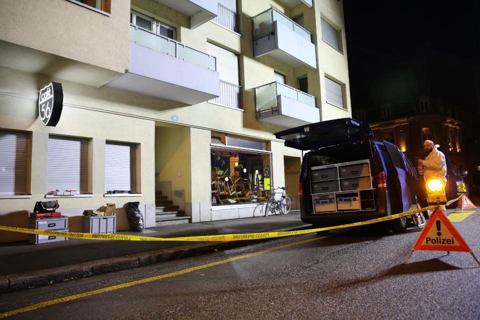 A forensic team member investigates the scene after deadly gunfire was unleashed in Cafe 56, Friday, March 10, 2017, in Basel, Switzerland. (AP Photo/Dominique Soguel)