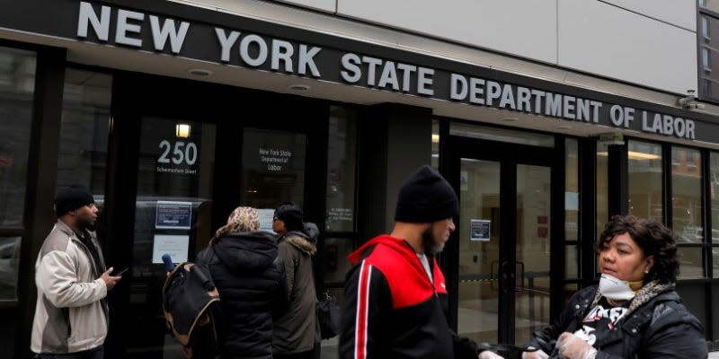 FILE PHOTO: People gather at the entrance for the New York State Department of Labor offices, which closed to the public due to the coronavirus disease (COVID-19) outbreak in the Brooklyn borough of New York City, U.S., March 20, 2020. REUTERS/Andrew Kelly/File Photo