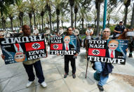 Three anti-Trump demonstrators protest as Orange County Sheriff officers stand watch outdoors before Republican U.S. Presidential candidate Donald Trump speaks at a campaign event in Anaheim, California U.S. May 25, 2016. REUTERS/Mike Blake