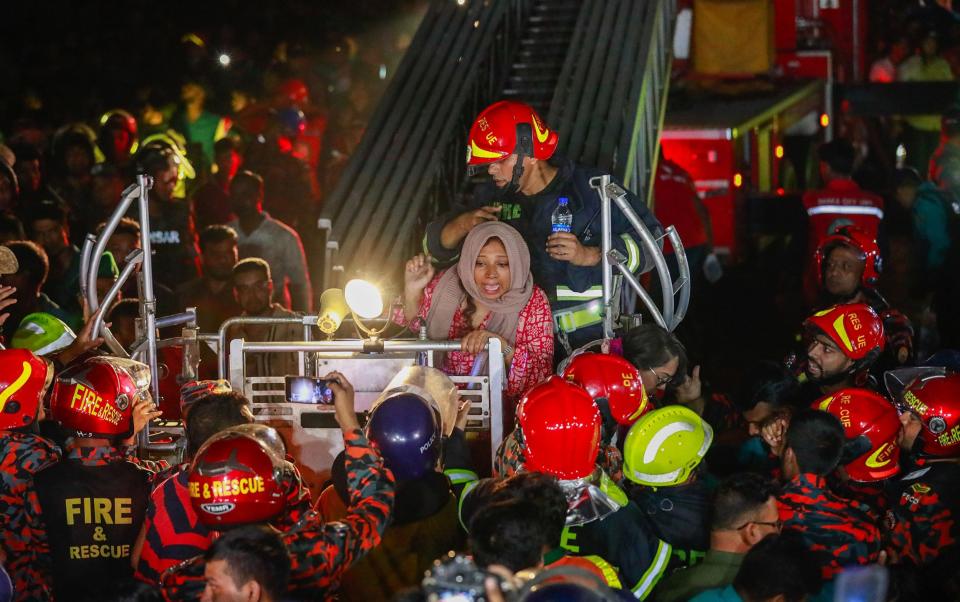 Firefighters rescue survivors who were trapped inside the building by the flames and heavy smoke