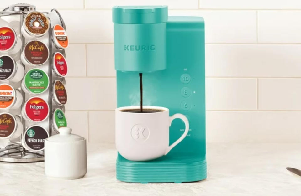 an teal keurig machine making a cup of coffee on a kitchen counter