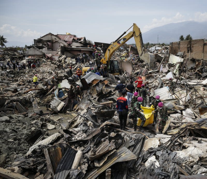 Rescuers and military personnel carry the body bag of a victim through an earthquake-devastated area in Balaroa, Palu, Central Sulawesi, Indonesia, on October 4, 2018. Some 1,500 people died after a series of powerful earthquakes hit Central Sulawesi on September 28, 2018, which triggered a tsunami. File Photo by Mast Irham/EPA-EFE