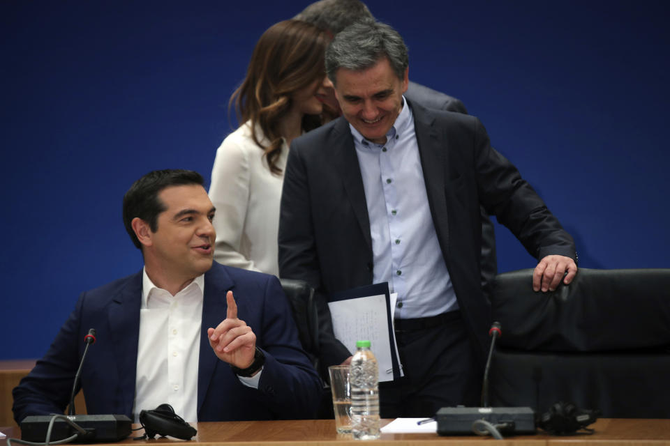 Greek Prime Minister Alexis Tsipras, left, speaks with Greek Financial Minister Euklid Tsakalotos as they arrive to take part on a new conference, in Athens, on Tuesday, May 7, 2019. Greece's left-wing prime minister has promised crisis-weary voters a series of tax-relief measures ahead of elections, after outperforming budget targets set by bailout creditors. (AP Photo/Petros Giannakouris)