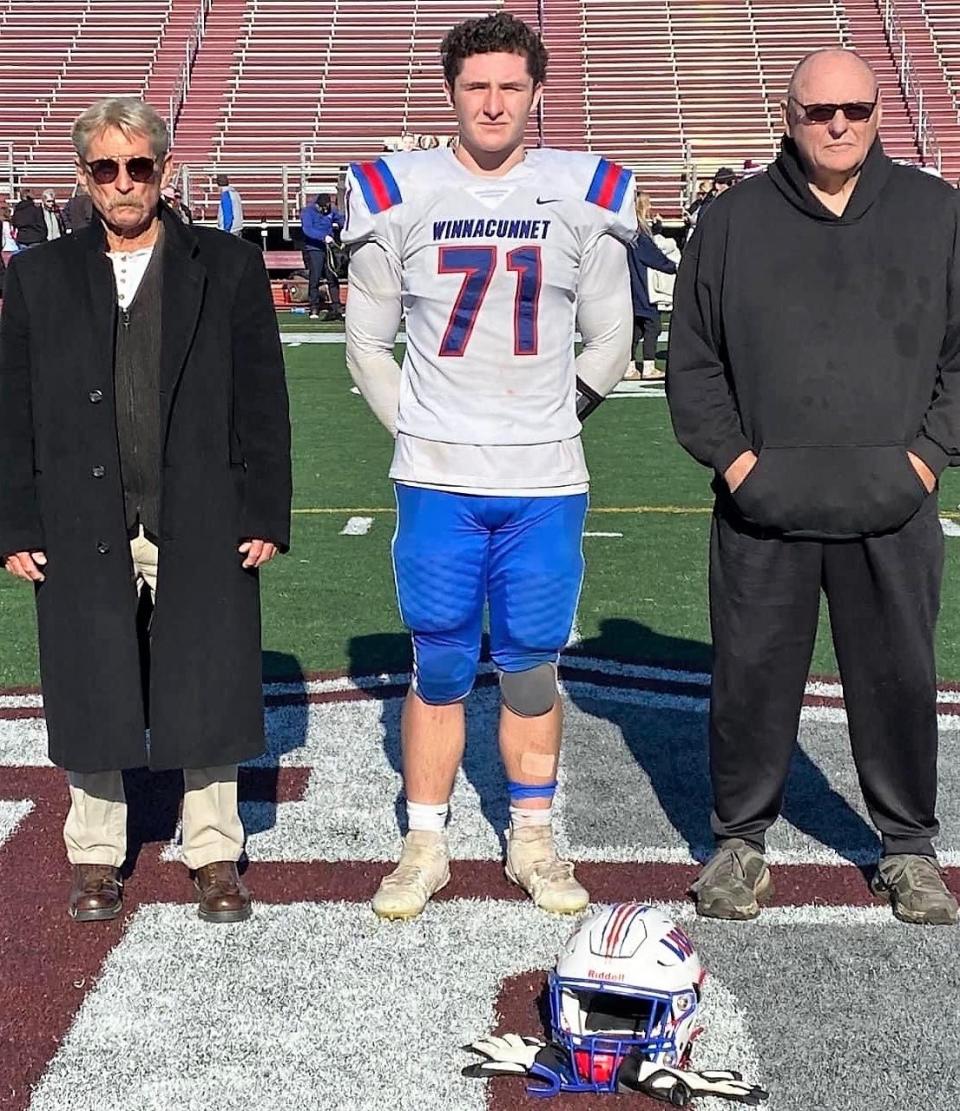 Winnacunnet High School senior football captain Jack Hogan stands with his uncles Stephen Begley, left, and Eddie Begley, at midfield of Edward D. Cawley Memorial Stadium in Lowell, Massachusetts Thanksgiving morning. Winnacunnet beat Lowell, 8-7 in the inaugural Friendship Bowl. Edward Cawley is the great-great-grand uncle to Jack, and great uncle to Steven and Eddie.