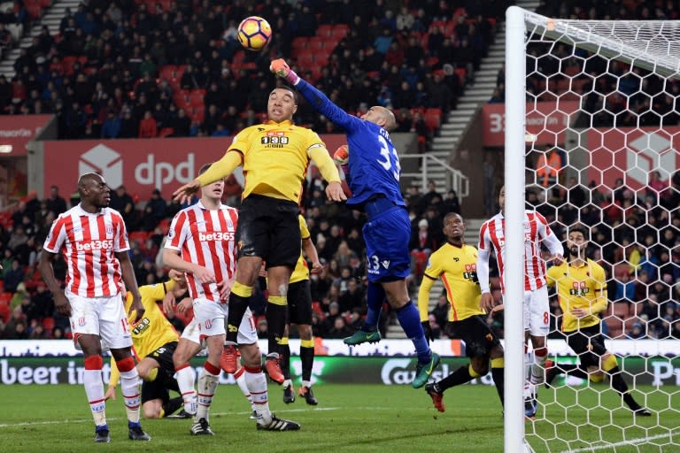 Stoke City's goalkeeper Lee Grant punches clear under pressure from Watford's striker Troy Deeney during the English Premier League football match January 3, 2017