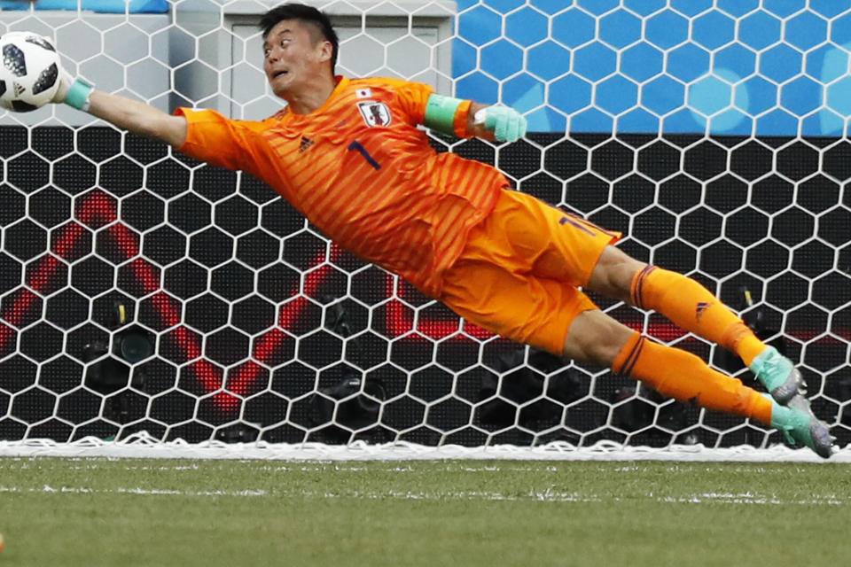 <p>Japan goalkeeper Eiji Kawashima makes a full-stretch save from Bartosz Bereszynski to keep the scores level </p>