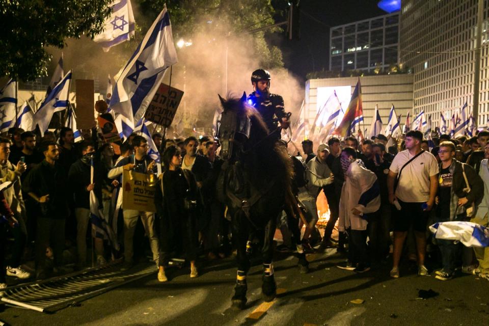 A mounted police officer surrounded by protestors (Getty Images)