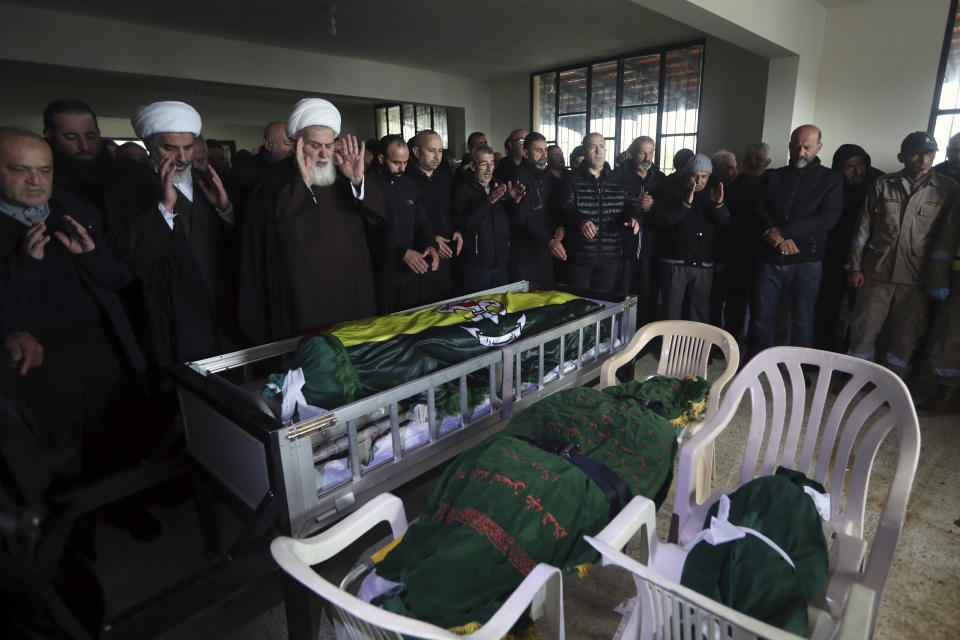 Mourners pray over the coffins of the victims who were killed in an Israeli strike last night, during their funeral procession in Qantara village, south Lebanon, Thursday, Feb. 15, 2024. The civilian death toll from two Israeli airstrikes in Lebanon has risen to 10, Lebanese state media reported Thursday, making the previous day the deadliest in more than four months of cross-border exchanges. (AP Photo/Mohammed Zaatari)