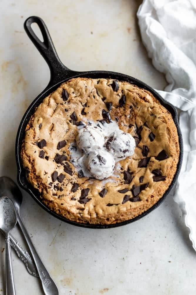 A skillet chocolate chip cookie topped with ice cream.