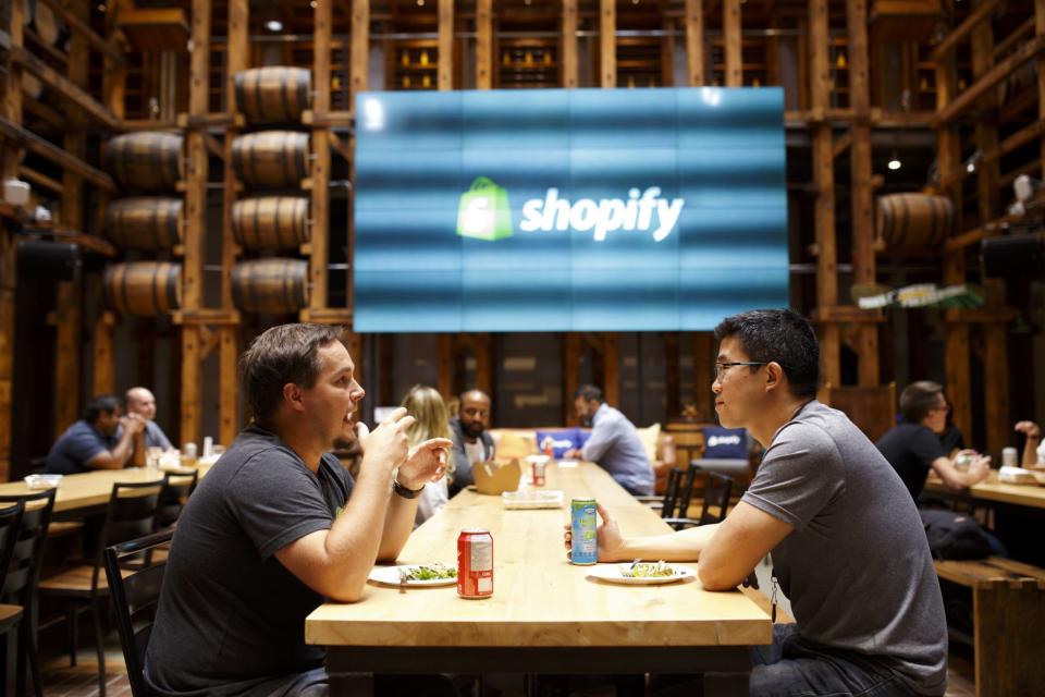 (Bloomberg) -- Same-day shipping is becoming the norm for online shoppers but for smaller merchants it can be a logistical nightmare. That’s where Shopify Inc. can step in, says Ric Kostick, chief executive officer of 100% PURE.The natural skincare company ships up to 5,000 orders a day from its own warehouse in San Jose, California. That works fine for customers on the West Coast but it can take up to a week to get its bamboo blur powder and coconut shower gel to the rest of the U.S. The company contemplated setting up an East Coast warehouse but the prospect was technically daunting.“The hardest thing is programming the technology to route the packages the right way and route the orders based on what a customer orders and what inventory is available at each site. Shopify has built the technology to calculate this,” says Kostick, who co-founded 100% PURE in 2004. “This is something I’ve wanted for years.”When Shopify said last month that it was moving into the fulfillment business -- essentially charging online merchants to store and ship their products -- the shares spiked and analysts began talking about the Canadian upstart as a potential competitor to Amazon.com Inc.It’s unlikely to become a serious threat to Amazon at this point. But many analysts believe the Ottawa-based company’s decision to add logistics to its range of online services is smart because it could help keep customers loyal, fend off competition and create an additional source of revenue. The move also could potentially pry small merchants from Amazon, which is focusing more on mega brands like Procter & Gamble Co.“A merchant is doing tens of millions of dollars in revenue but their fulfillment is a complete mess and that could prevent them from being successful,” says Taylor Sicard, a former Shopify employee who now runs a company that helps merchants set up e-commerce businesses. “It is a massive opportunity for Shopify.”Founded in 2006, Shopify had a simple pitch: pay us $29 a month and we’ll give you all the tools required to start an online business. Many Shopify customers fail, but the more successful they are, the more money Shopify makes through transaction fees and higher-priced subscription tiers. Its Shopify Plus premium service, which counts Kylie Jenner, The New York Times and 100% PURE as its customers, can cost at least $2,000 per month.Investors love the model. Shopify shares have soared more than 1,800% since the company went public in May 2015, making it one of Canada’s most successful startups. The stock has been hitting records almost daily and now has a market value of C$48.73 billion ($37 billion), bigger than two the country’s oldest financial heavyweights, Manulife Financial Corp. and Canadian Imperial Bank of Commerce.But Shopify has struggled to make a profit and is poised to report a net loss of $35 million on sales of $320 million for the second quarter on Aug. 1, according to the average of analyst estimates compiled by Bloomberg.As the company matures, meanwhile, it will be harder to sustain the average 74% year-over-year revenue growth rates it has managed over the past three years. There are also concerns that Shopify relies too heavily on a few, large merchants that use its premium services. Most of the company’s customers, which amounted to over 820,000 as of June, are smaller and tend to flame out on a regular basis, creating considerable churn.That’s where the fulfillment service comes in. The company has pledged to negotiate low rates with warehouses and shipping companies, then pass those savings on to its customers. In the future, Shopify could pool shipments from different merchants together, making shipping faster and cheaper and gaining some of the same advantages Amazon gets from its centralized fulfillment network.Initial PhaseIt’s partnered with logistics firms to offer the service to merchants shipping orders of 10 to 10,000 items in seven warehouses in states including Nevada, California, and Texas in the initial phase.“Right now it is really important that we invest in the right growth opportunities for the future and not necessarily take our foot off the gas,” says Harley Finkelstein, Shopify’s chief operating officer.Many merchants prefer using Shopify because they can create a brand on their own website, rather than being subsumed into an Amazon-style marketplace. The new fulfillment service will also let them slap their brand on the shipping cartons, something some fulfillment companies don’t offer.Kostick, who also sells his products on Amazon and uses its fulfillment network says the U.S. company provides access to one of the fastest-growing distribution channels for beauty products in the U.S., but Shopify offers more control.“You can customize your own website however you want,” he says. “Basically, you’re empowered.”Jennifer Harper, who also sells sustainable cosmetics through Shopify, says she will wait until Shopify sorts out any kinks before trying the fulfillment service. Others say it could be difficult and expensive to get out of existing contracts with standalone services in the short term.Happy MerchantsShopify says it could eventually build its own warehouses. While Shopify’s finance chief, Amy Shapero, has said that the company will be able to offset the cost with fees for the new service, some analysts say revenue will be limited at first because Shopify will need to offer discounts to lure merchants.Amazon may have little to fear from Canada’s most valuable tech company at this point. Still, Shopify offers a serious alternative to the Seattle leviathan.“Amazon is all about trying to satisfy the customer,” says Anurag Rana, a senior analyst at Bloomberg Intelligence. “They do whatever they can in their power to squeeze money out of the merchants to give it to customers. Shopify is the exact opposite. They will do whatever it takes to help the merchant and maximize their profit.”(Updates with share price and market cap in seventh paragraph)To contact the reporter on this story: Simran Jagdev in Toronto at sjagdev1@bloomberg.netTo contact the editors responsible for this story: Jacqueline Thorpe at jthorpe23@bloomberg.net, ;Jillian Ward at jward56@bloomberg.net, Robin AjelloFor more articles like this, please visit us at bloomberg.com©2019 Bloomberg L.P.