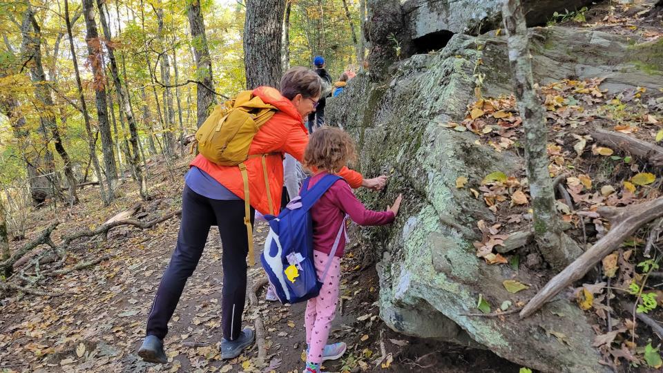 Kim Gundler with Conserving Carolina touches a boulder with a FernLeaf Charter School student on the Oct. 11 hike on the Bearwallow Mountain Trail.