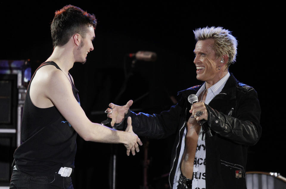 Billy Idol, right, is joined on stage by Michael Henrichsen, left, as Idol performs Friday, Oct. 26, 2012, in Seattle. Idol came to play in Seattle after Henrichsen launched a two-year grass-roots campaign to convince the rock star to play for his birthday party. (AP Photo/Ted S. Warren)